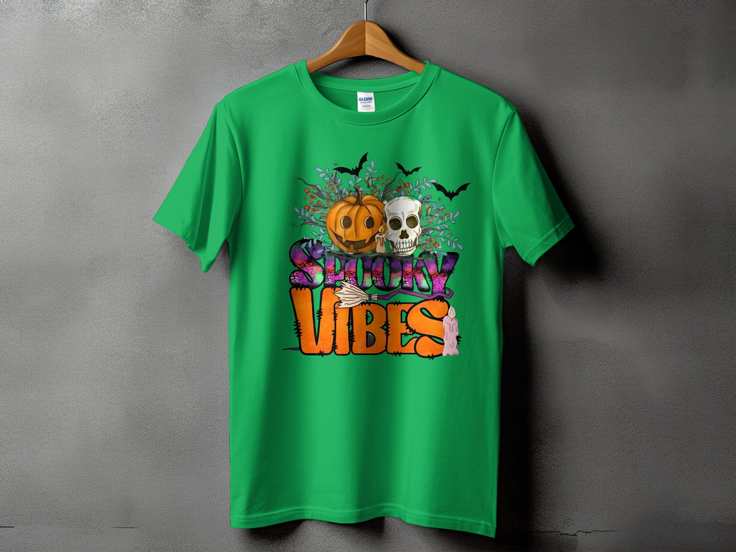 Green t-shirt with "Spooky Vibes" text, pumpkin, skull, bats, and candle graphic.