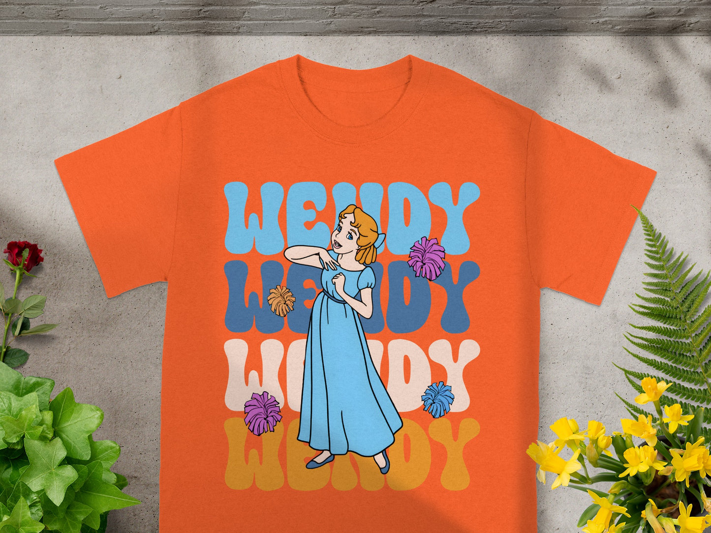 Orange t-shirt with Wendy text and cartoon of girl dancing.