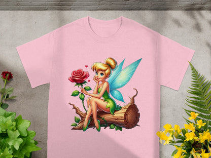 Fairy with blue wings and a rose sits on a log.