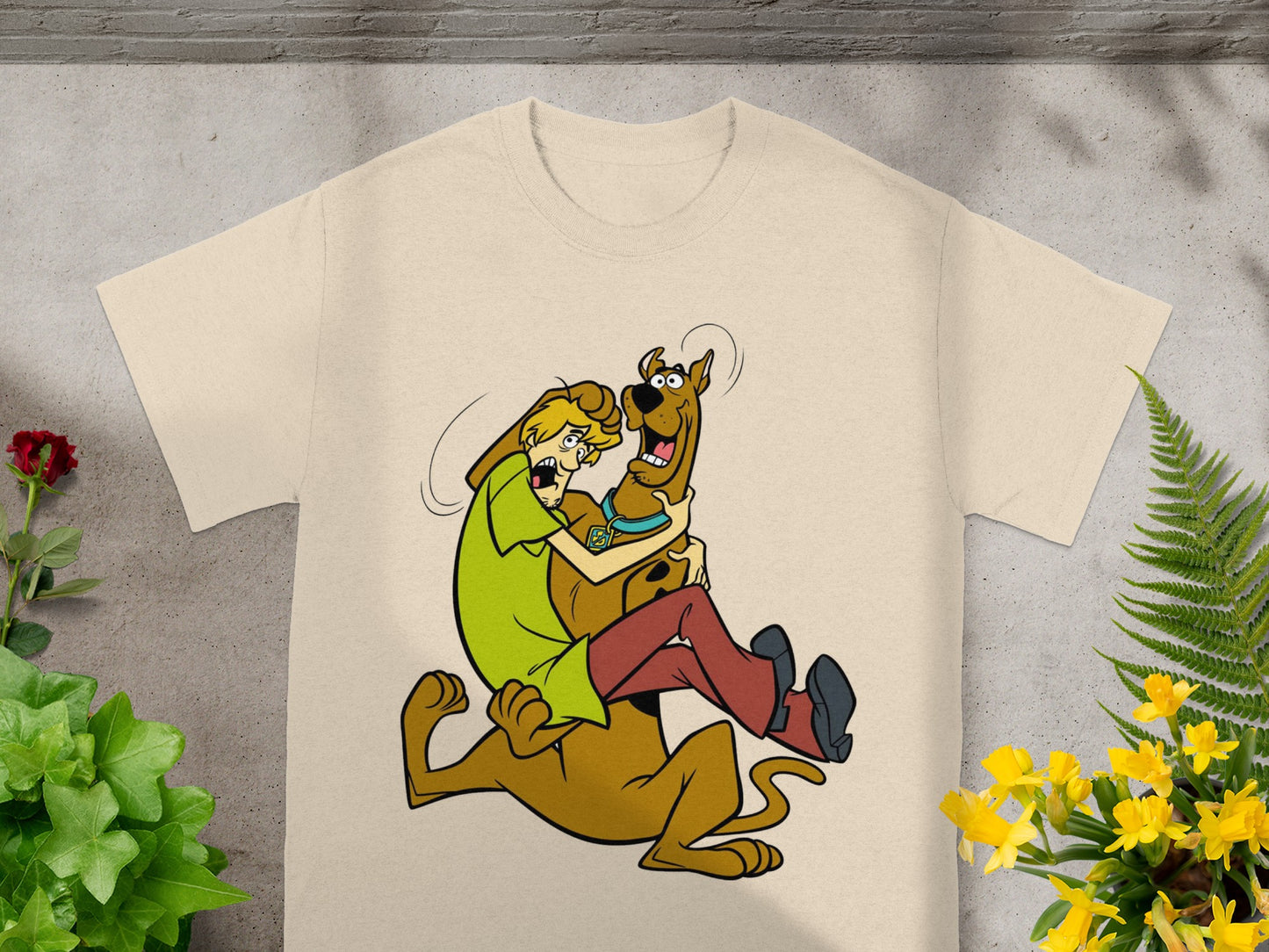 Shaggy and Scooby-Doo graphic on a light tan t-shirt with plants.