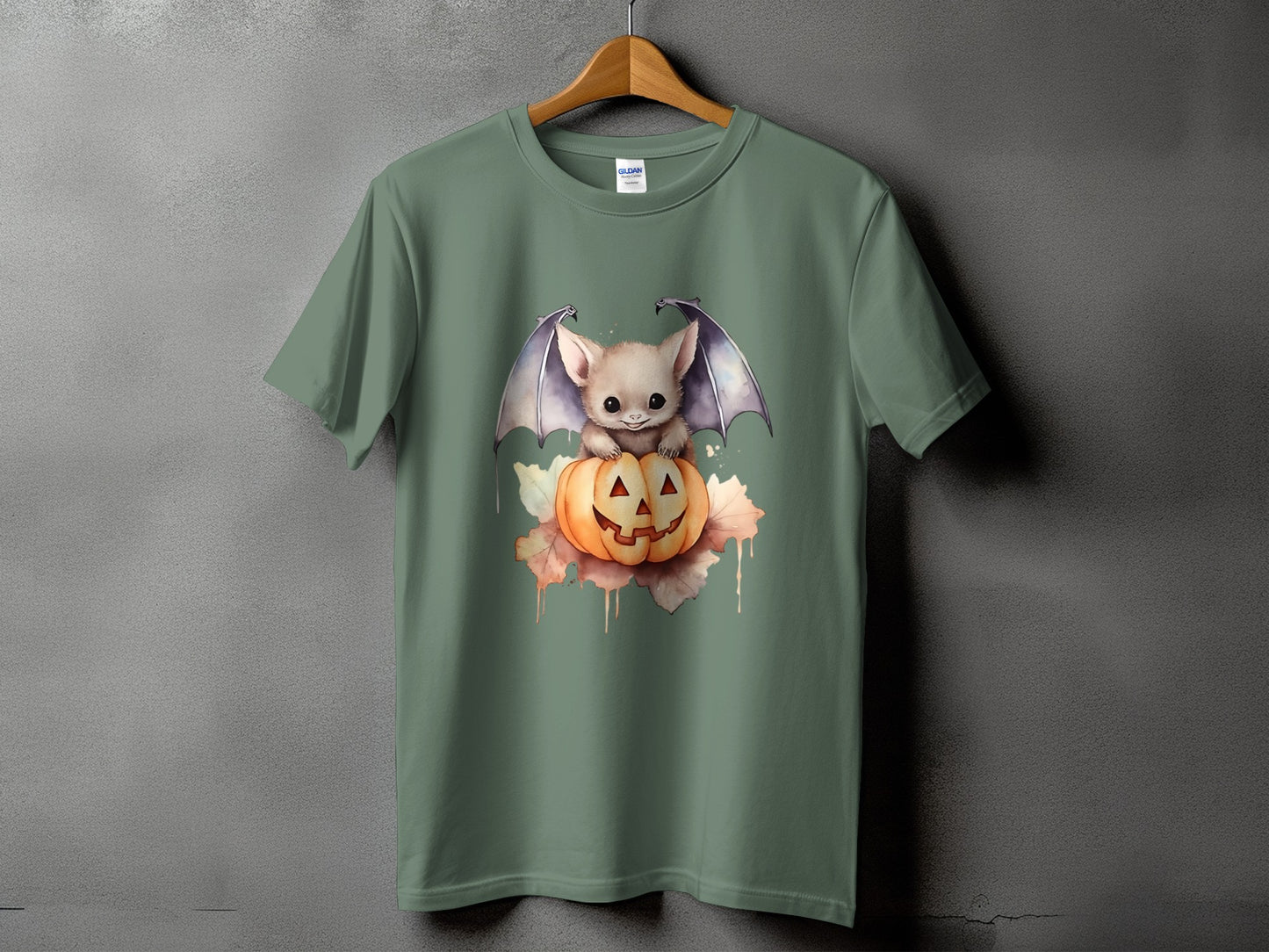 Green t-shirt with a cute bat sitting on a Halloween pumpkin.