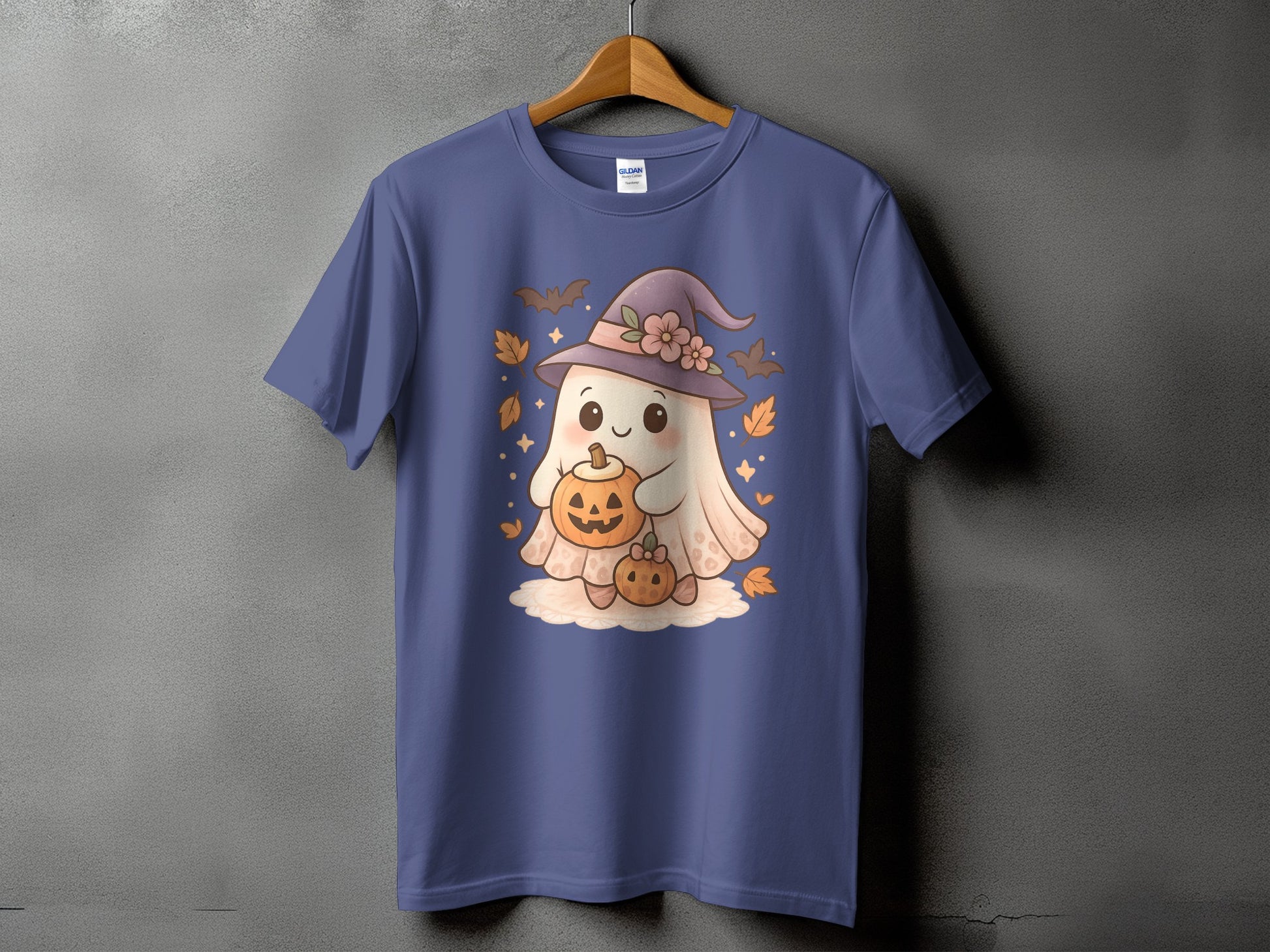 Blue t-shirt with a cartoon ghost wearing a witch hat and holding pumpkins.
