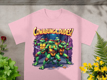 Teenage Mutant Ninja Turtles with swords and "Cowabunga, Dudes!" text on pink t-shirt.