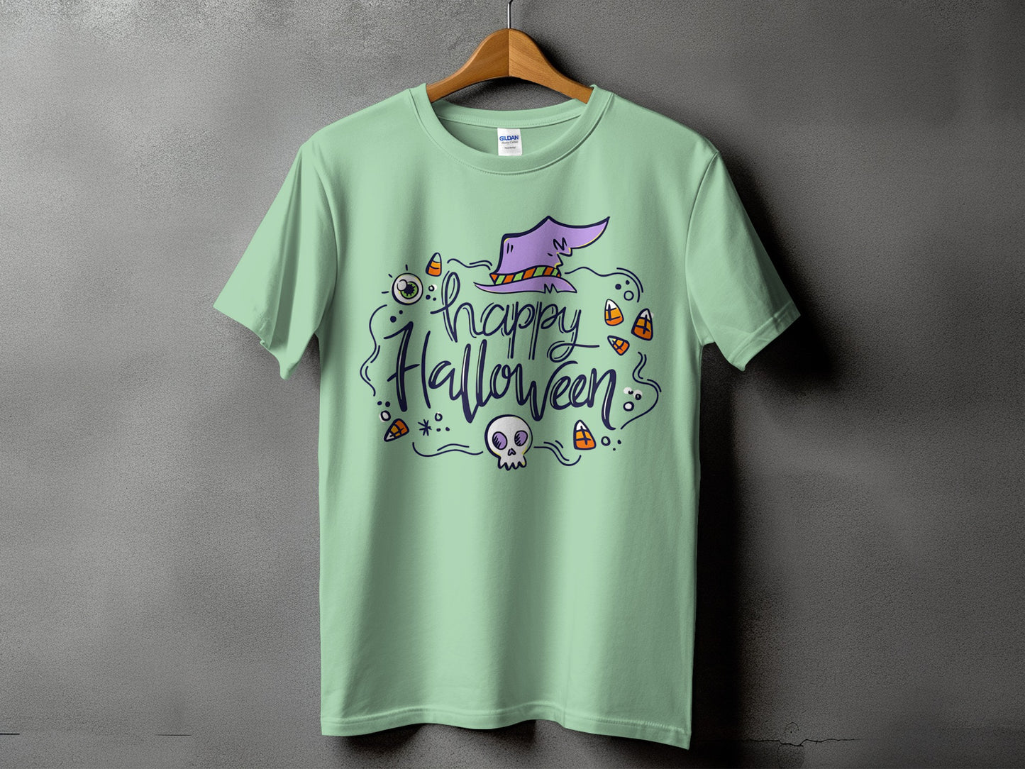 Light green t-shirt with "Happy Halloween" text, a witch hat, skull, and candy corn.