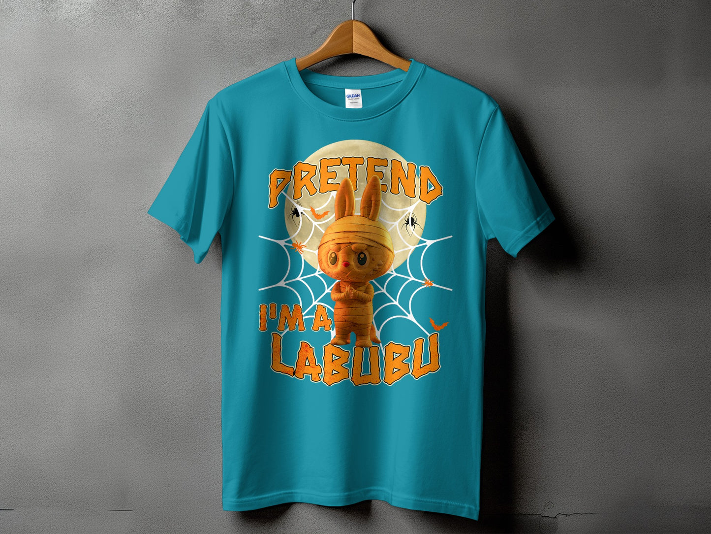 Teal t-shirt with a mummy-like bunny graphic and text "PRETEND I'M A LABUBU".
