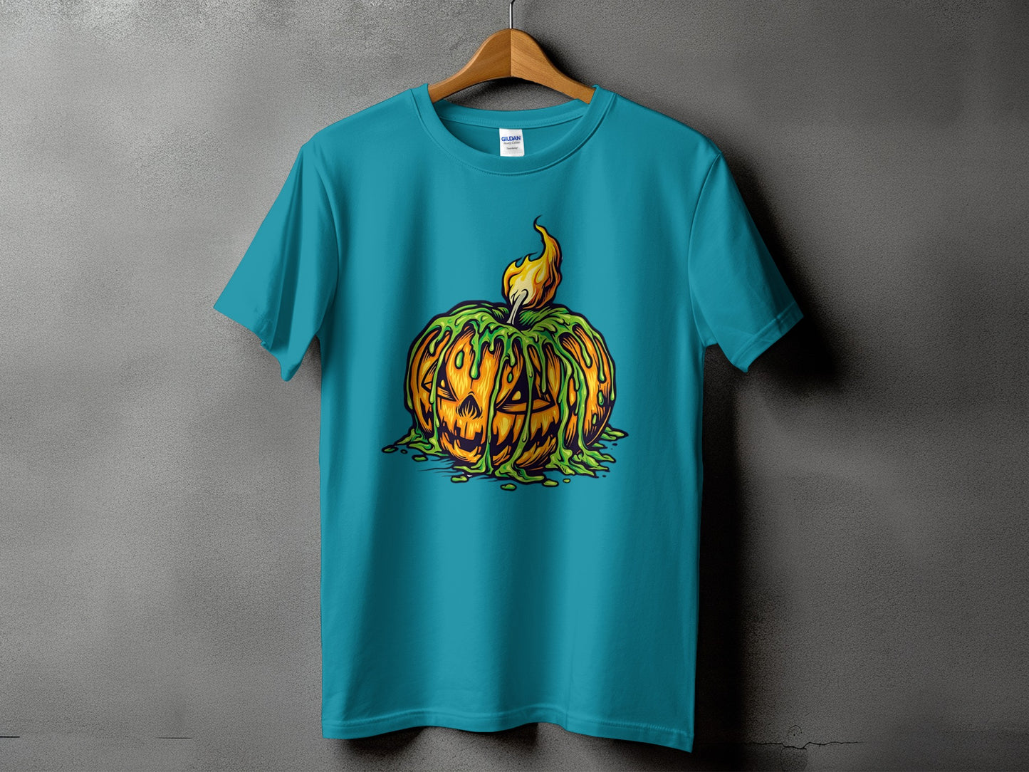 Teal t-shirt with a dripping jack-o-lantern graphic and a flame on a gray background.