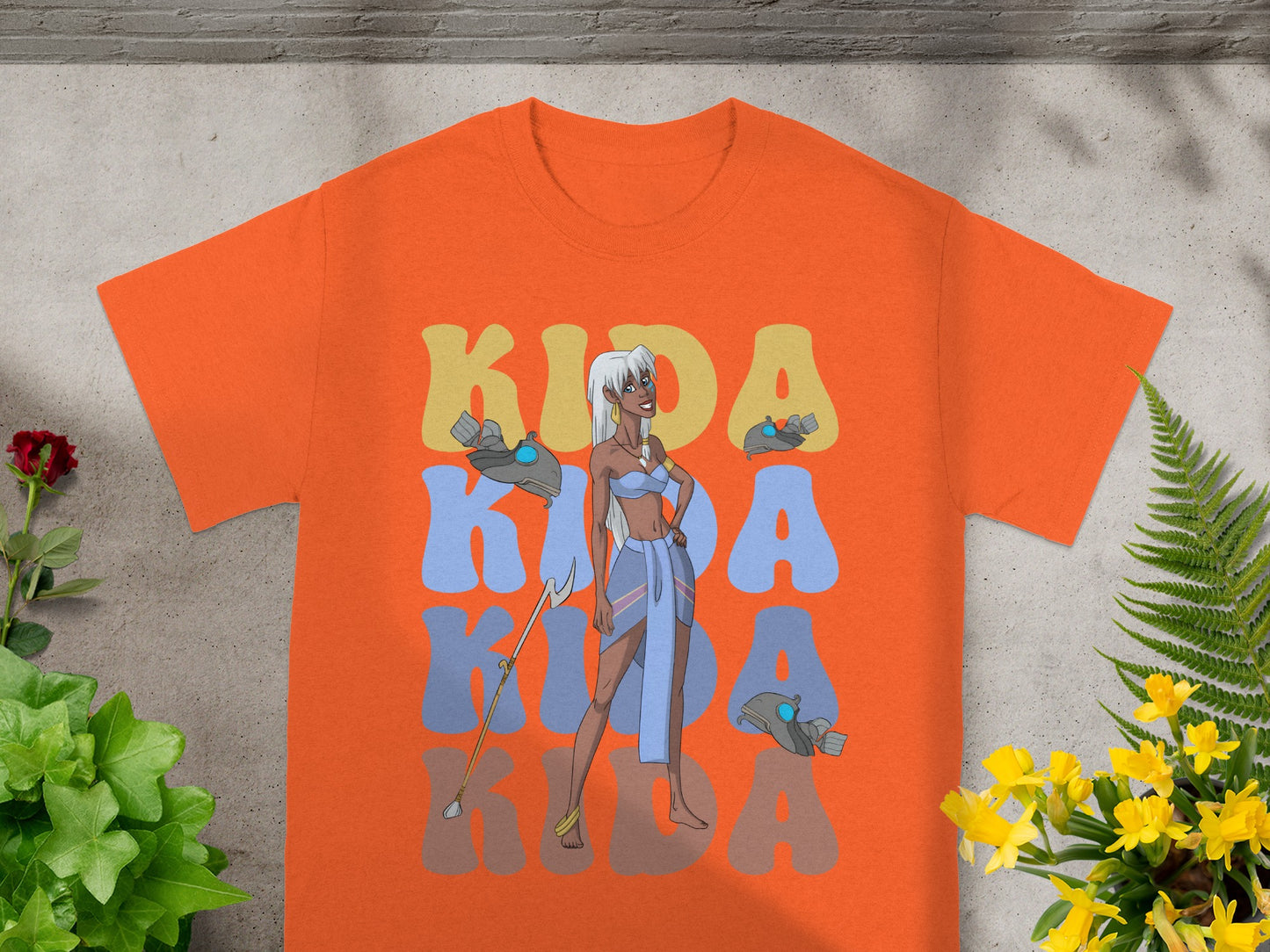Orange t-shirt with "Kida" in large, stylized letters and character graphic.