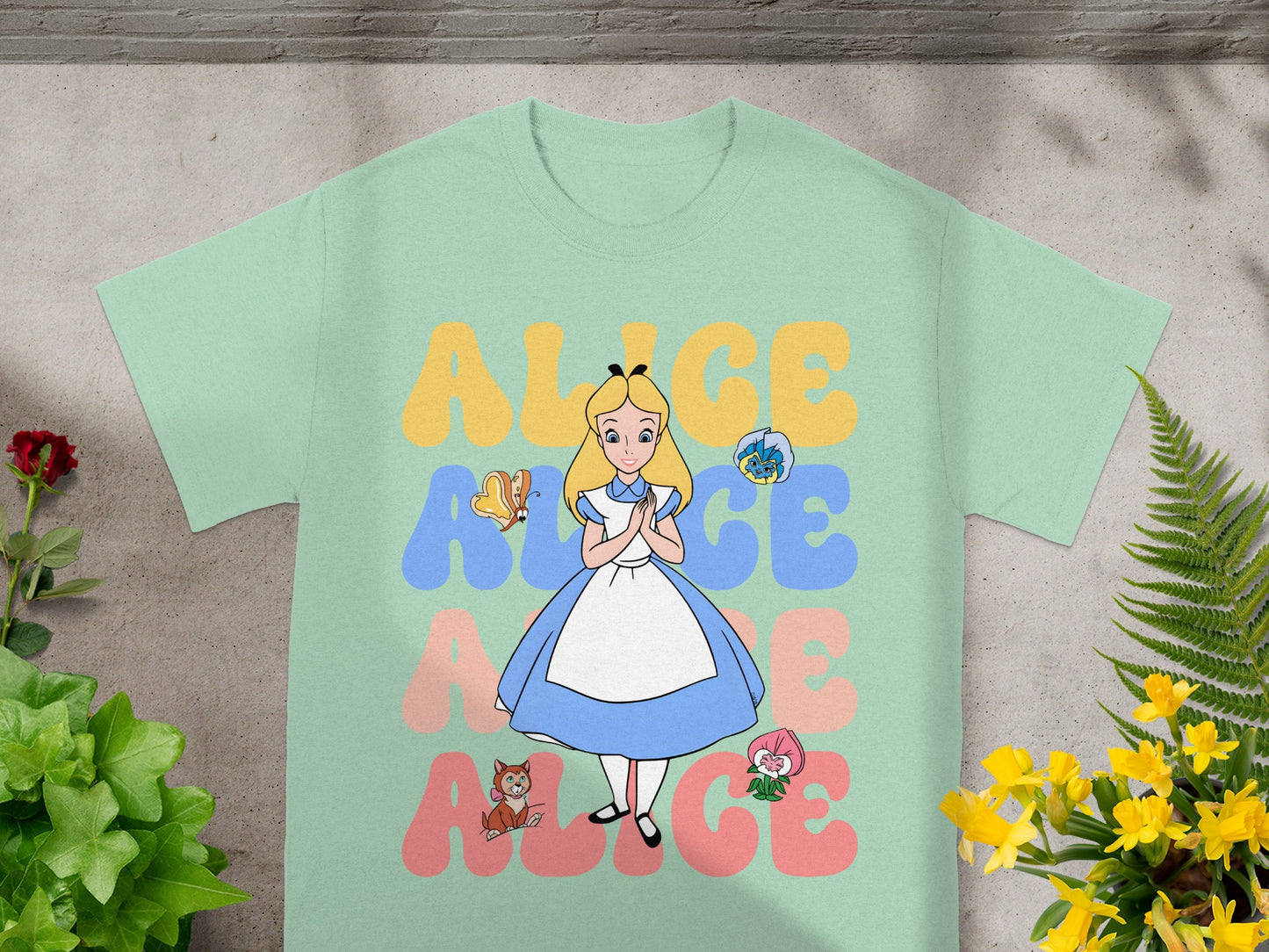 Alice in Wonderland graphic tee with character and flowers.