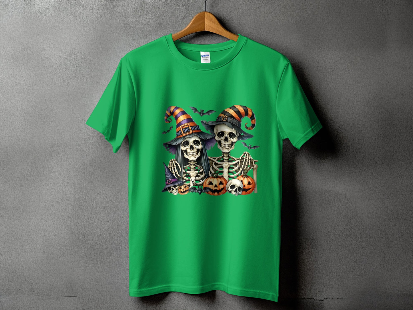 Green t-shirt with two skeletons in witch hats and pumpkins, bats and skulls.