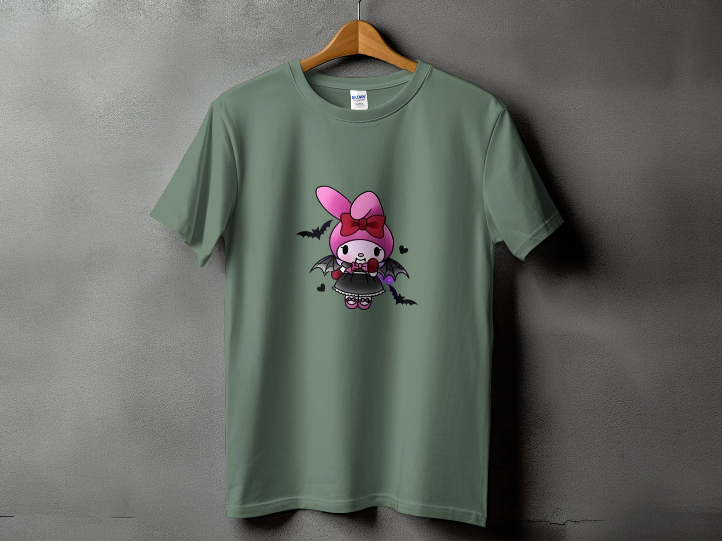 Olive green t-shirt with a cartoon vampire bunny wearing a pink bow and black dress.
