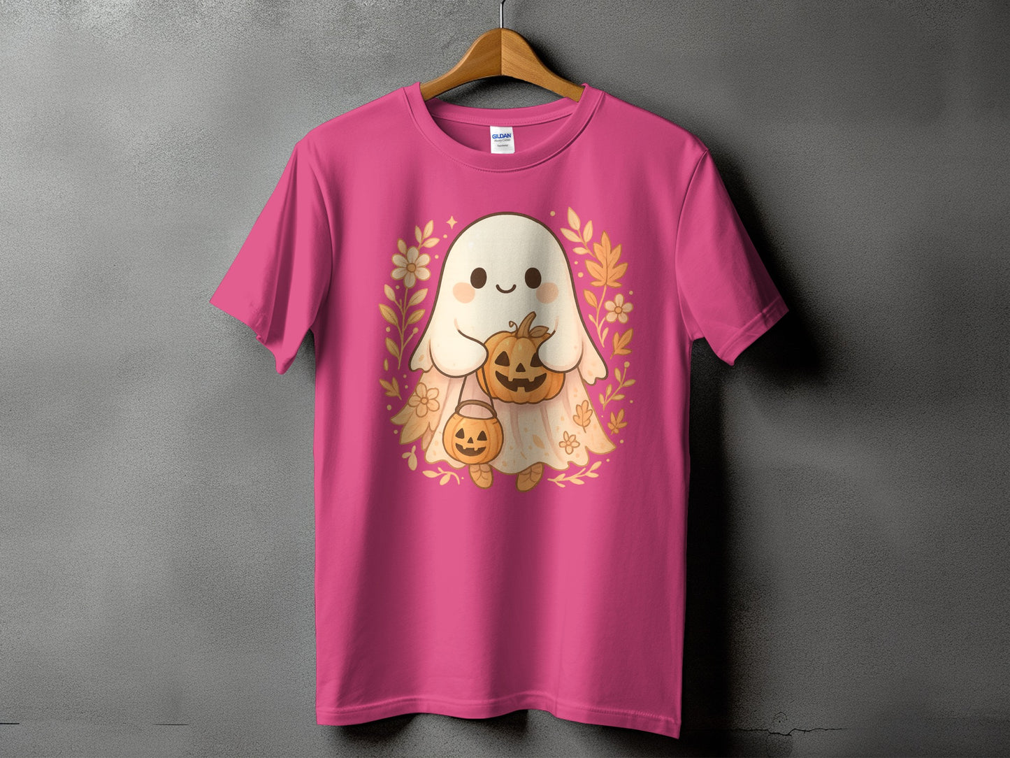 Pink t-shirt with a cute ghost holding pumpkins and surrounded by fall foliage.