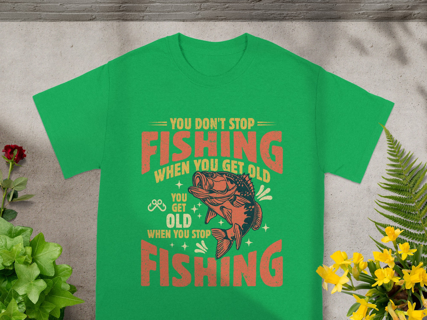 Green t-shirt with "You Don't Stop Fishing When You Get Old" graphic.