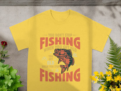 Yellow t-shirt with "You Don't Stop Fishing When You Get Old" text and fish graphic.