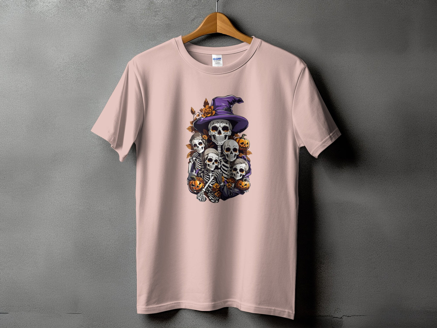 Skeleton and pumpkin Halloween graphic on a light pink t-shirt.