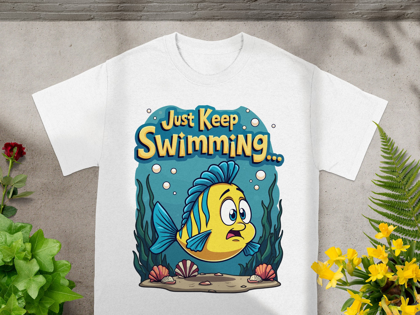 White t-shirt with cartoon yellow fish and "Just Keep Swimming" text.