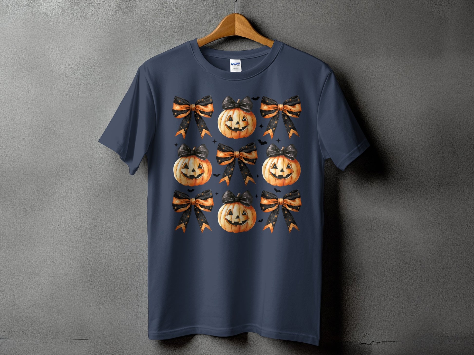 Dark blue t-shirt with a repeating pattern of jack-o'-lanterns and bows.