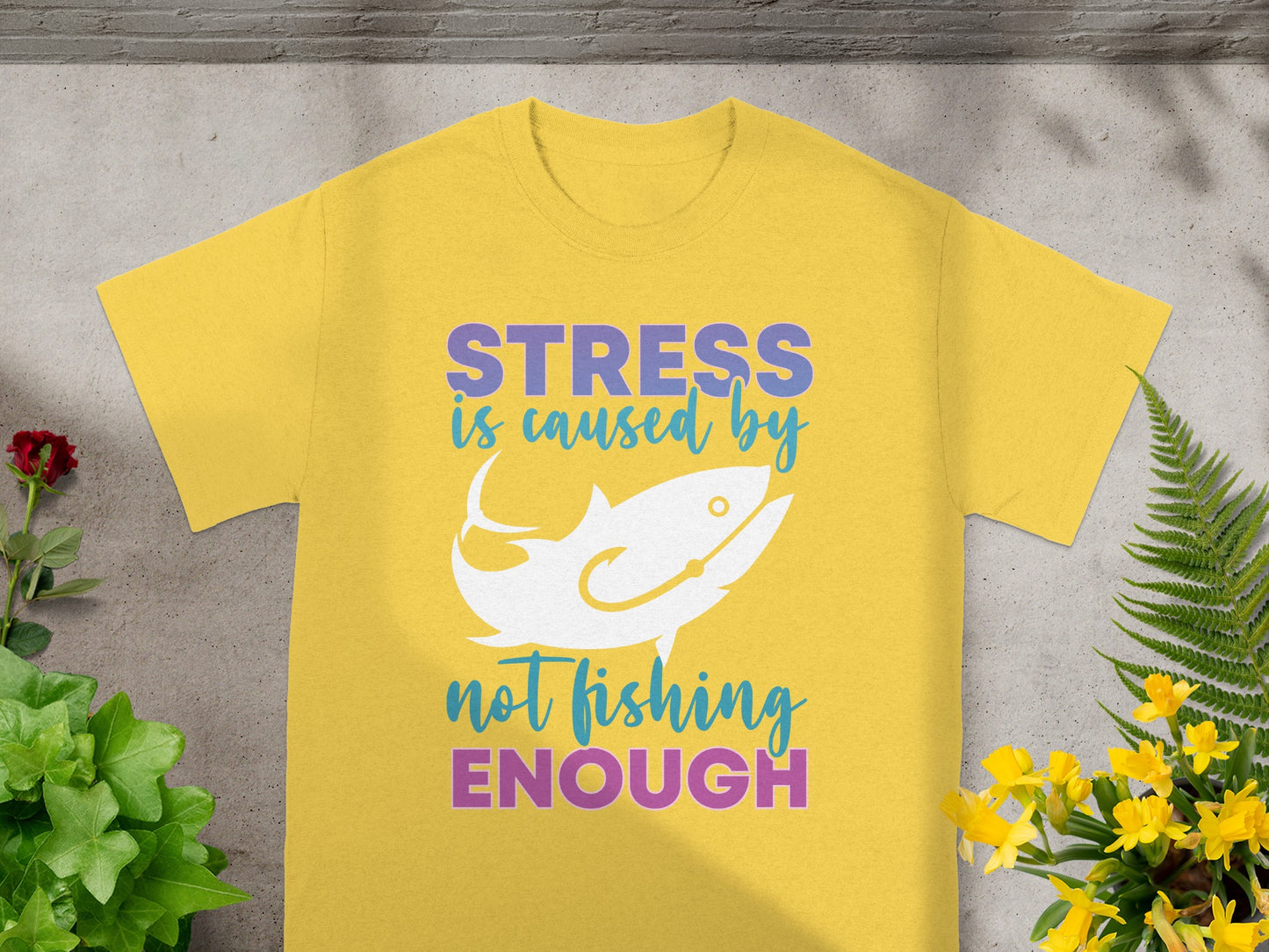 Yellow t-shirt with text "STRESS is caused by not fishing ENOUGH" and a fish graphic.