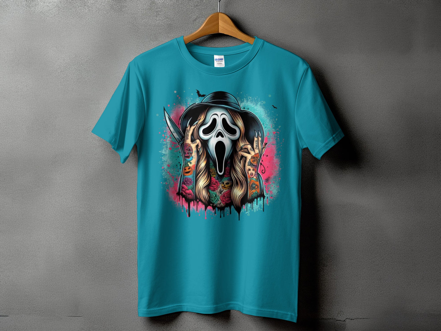 Teal t-shirt with a graphic of a ghost face mask, knife, and floral tattoos.