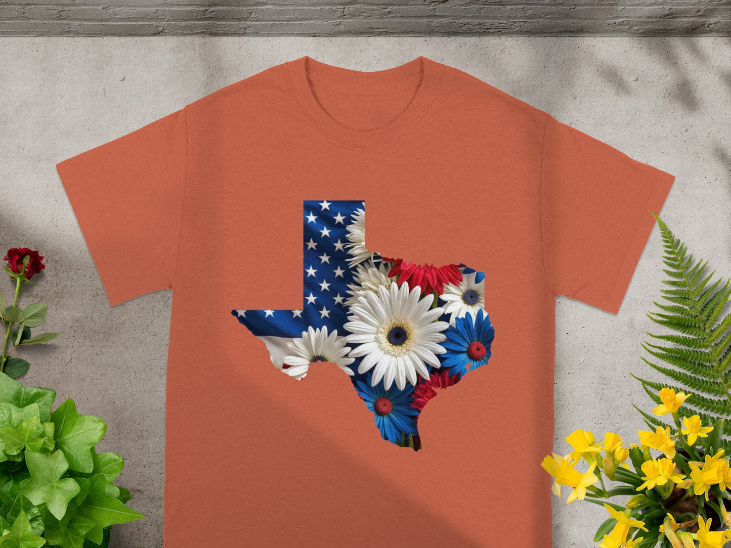 Orange t-shirt featuring Texas map outline filled with American flag and flowers.