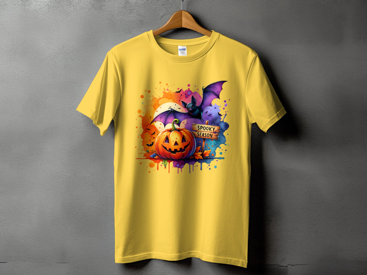 Yellow t-shirt with Halloween graphic: pumpkin, bat, and "Spooky Season" sign.