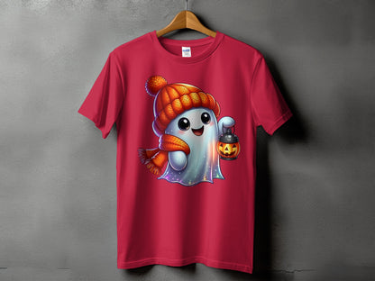 Pink t-shirt featuring a cartoon ghost wearing a beanie and scarf, holding a pumpkin lantern.