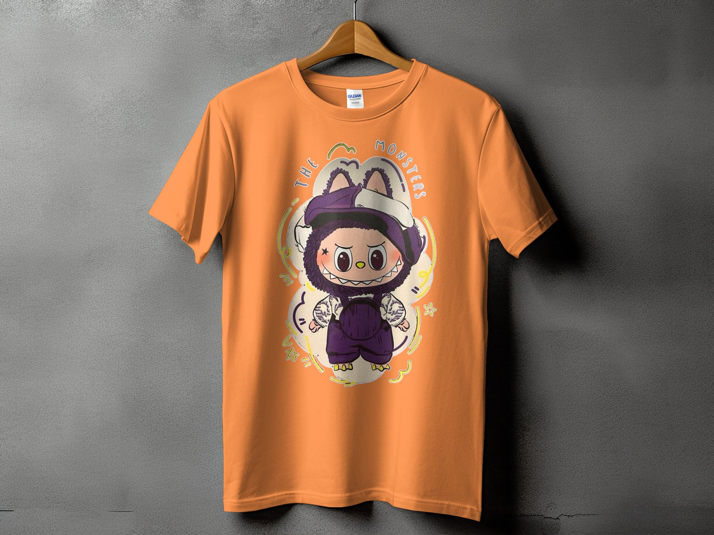 Orange t-shirt with cartoon monster graphic and text "THE MONSTERS"