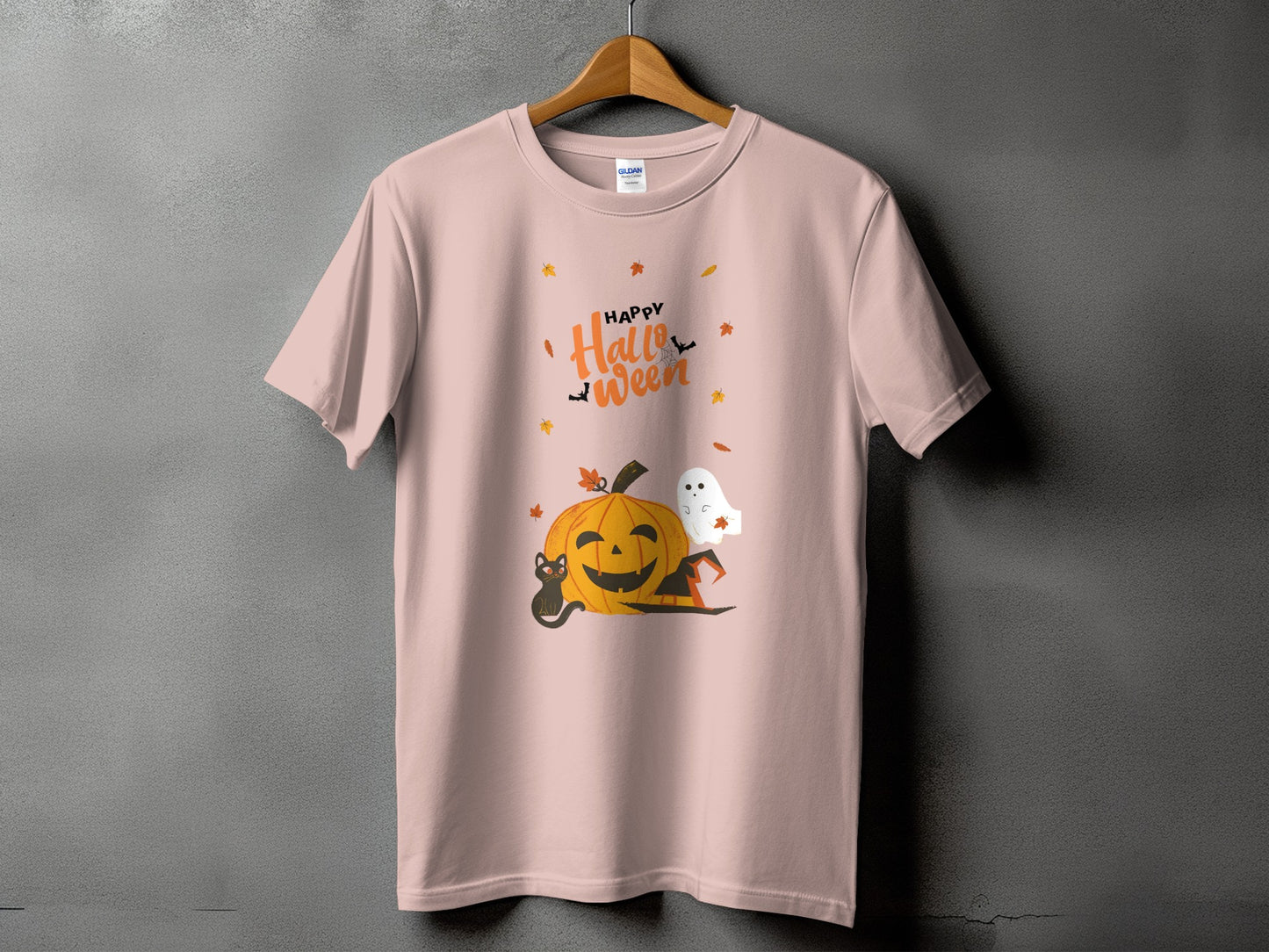 Pink t-shirt with happy Halloween graphic of pumpkin, cat, ghost, and hat.