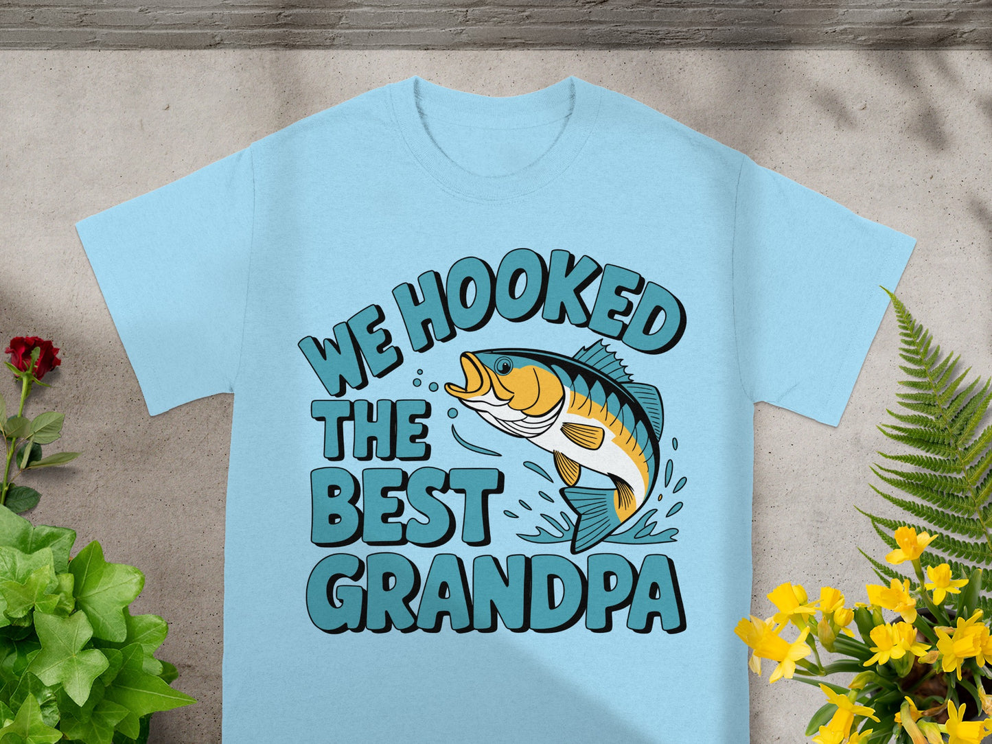 Light blue t-shirt with text "WE HOOKED THE BEST GRANDPA" and a fish graphic.
