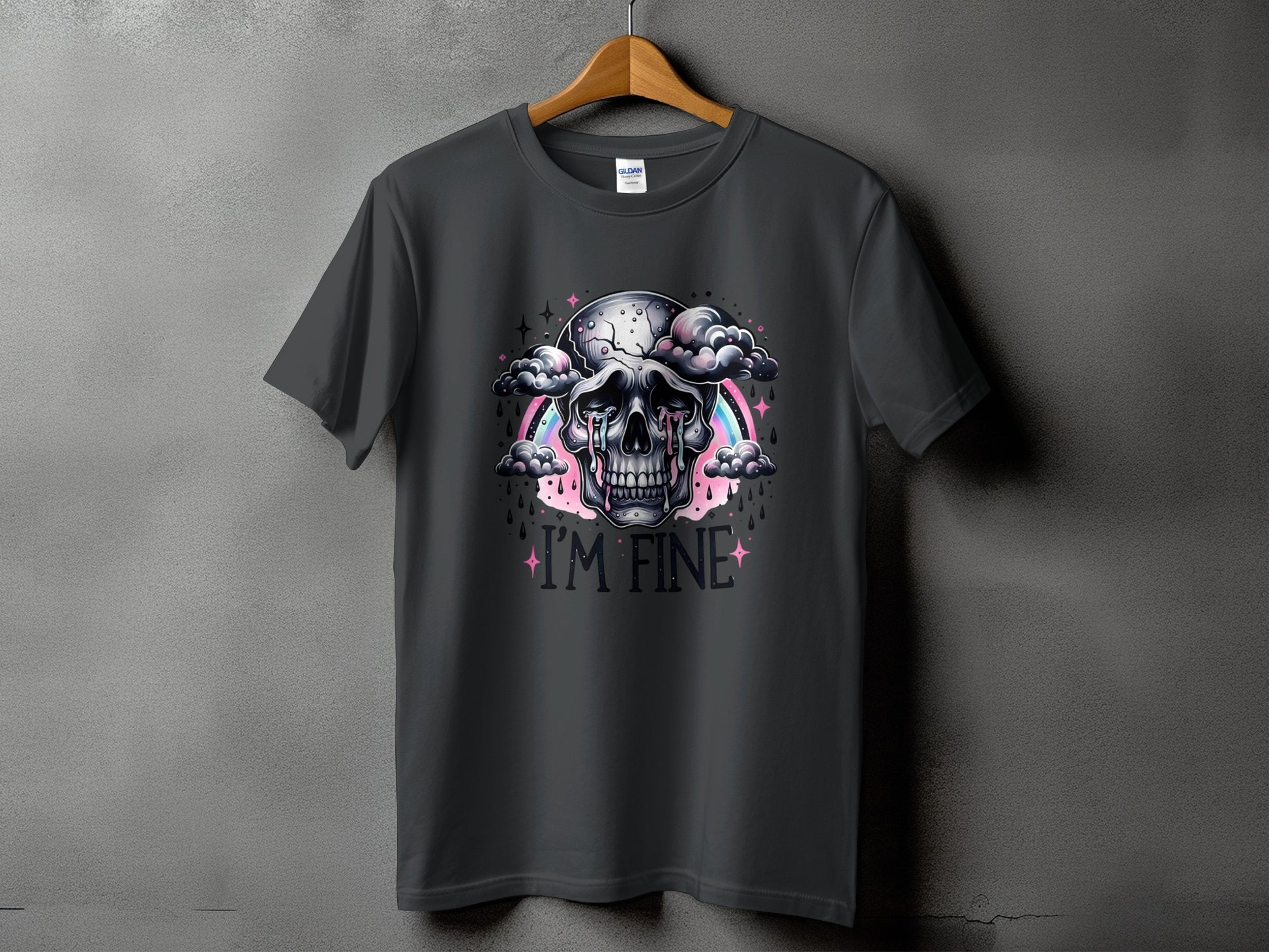 Dark grey t-shirt featuring a skull crying amidst clouds, with a rainbow and the text "I'M FINE".