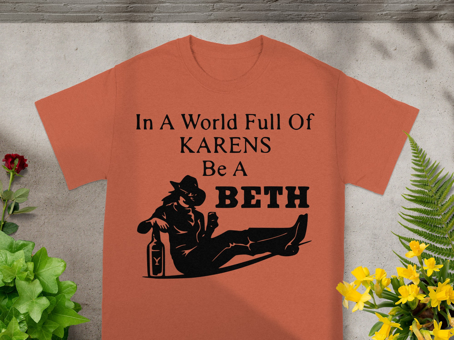 Orange t-shirt with the text "In A World Full Of KARENS Be A BETH" and a silhouette.
