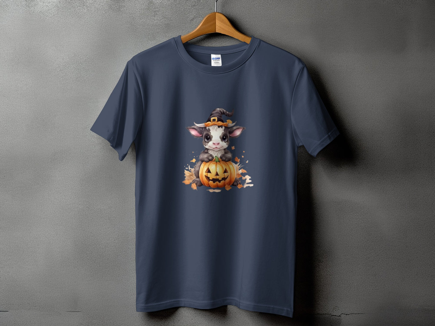 Dark blue t-shirt with a cute cow wearing a witch hat sitting on a pumpkin.