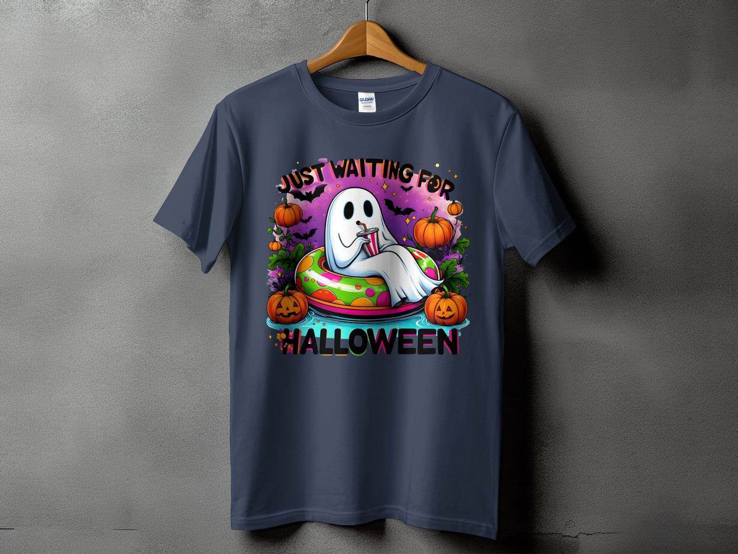 Ghost in inner tube with pumpkins says "Just Waiting For Halloween".