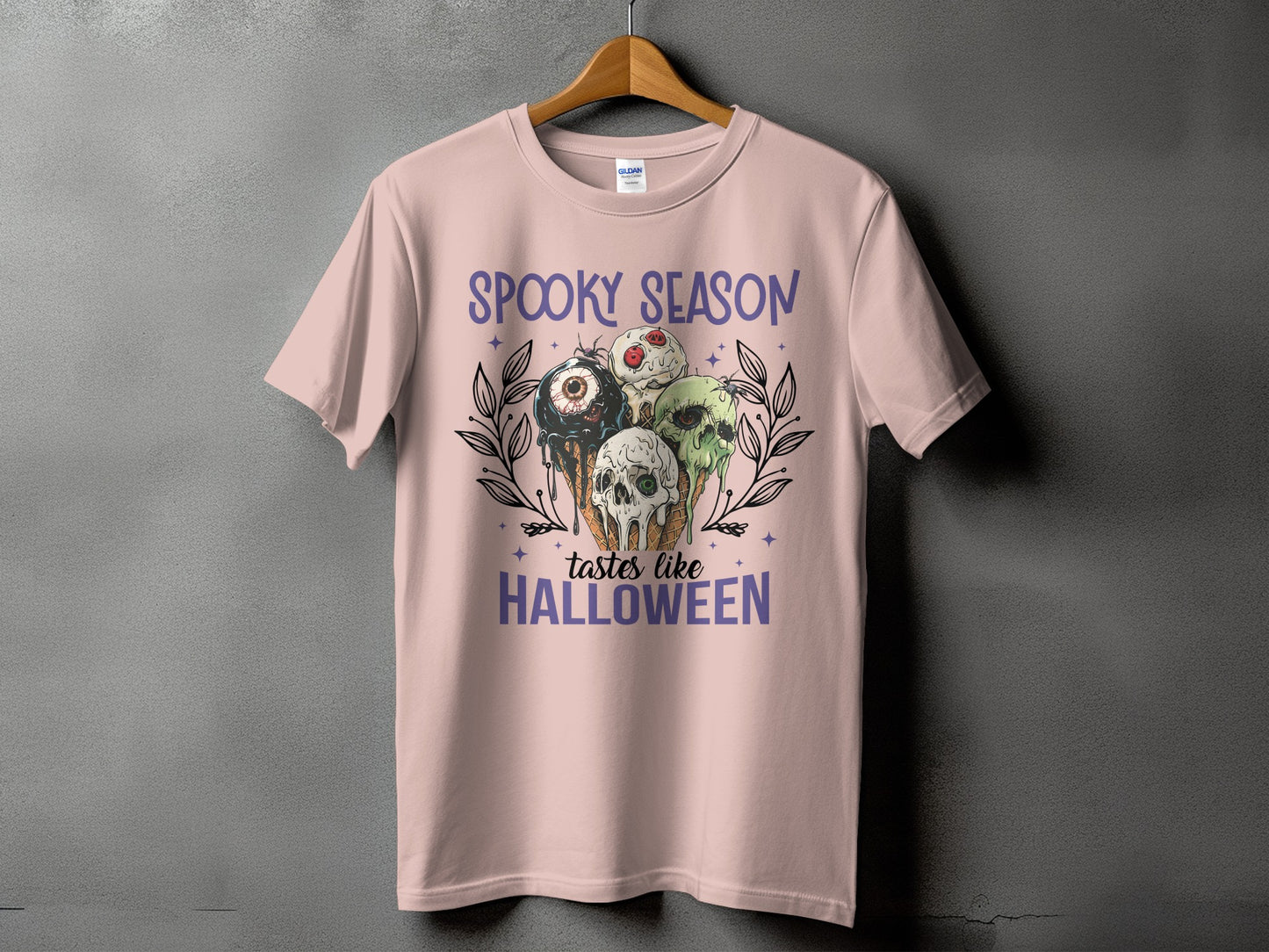 Pink t-shirt with "Spooky Season Tastes Like Halloween" text and Halloween-themed ice cream cones.