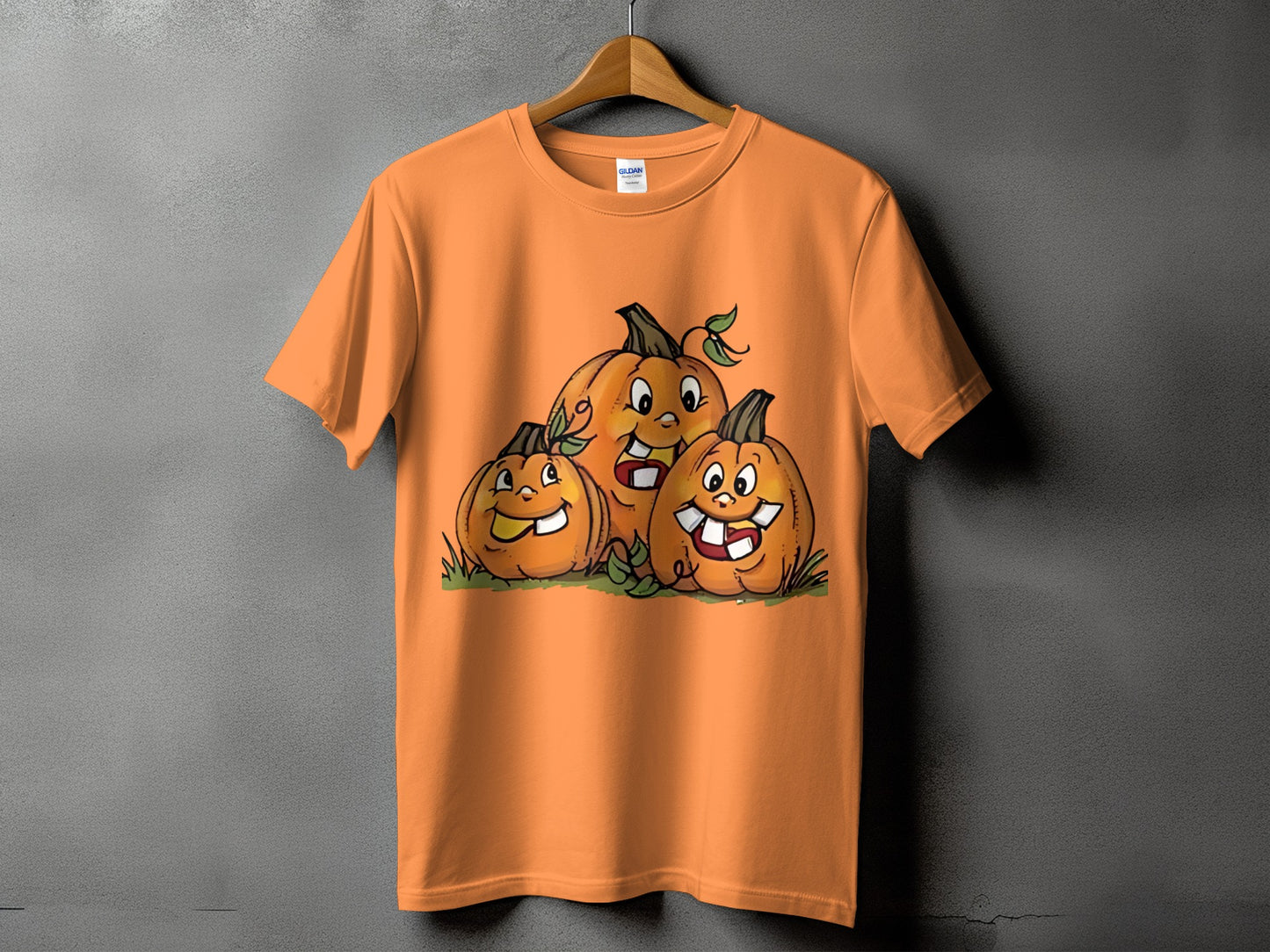 Three cartoon pumpkins with funny faces on an orange t-shirt.