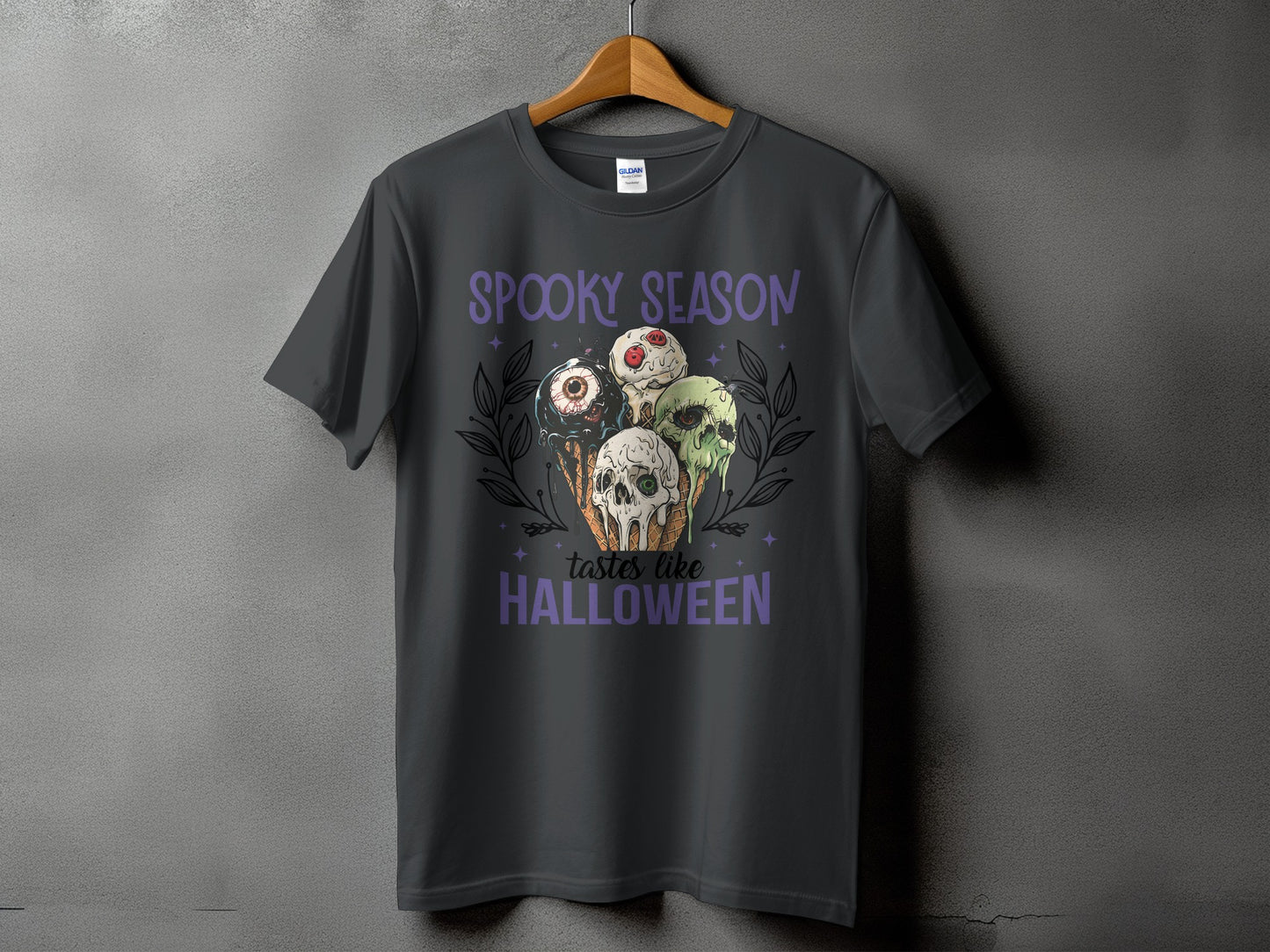 Dark gray t-shirt with "Spooky Season Tastes Like Halloween" and spooky ice cream graphic.