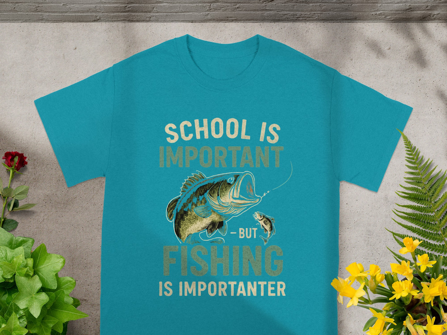 Teal t-shirt with graphic of bass fish and text "SCHOOL IS IMPORTANT - BUT FISHING IS IMPORTANTEN".