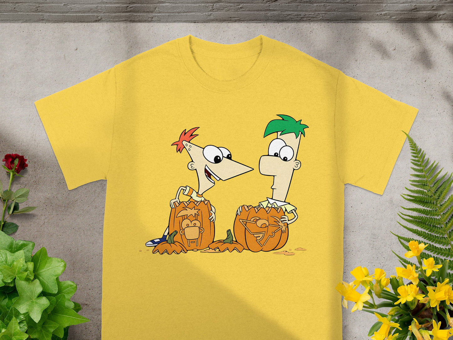 Phineas and Ferb characters with carved pumpkins on a yellow t-shirt.