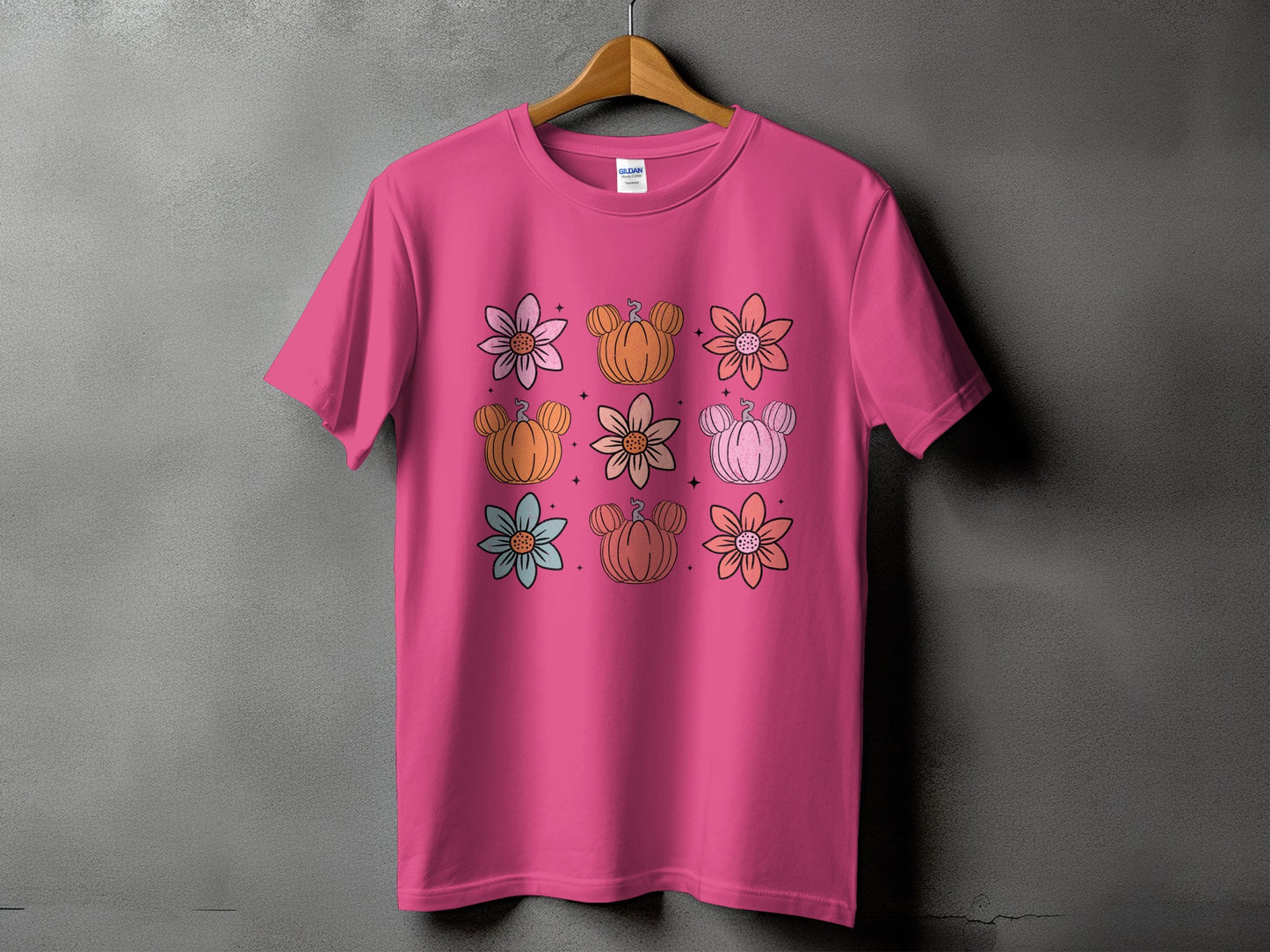 Pink t-shirt with a grid of flowers and Mickey Mouse-shaped pumpkins.