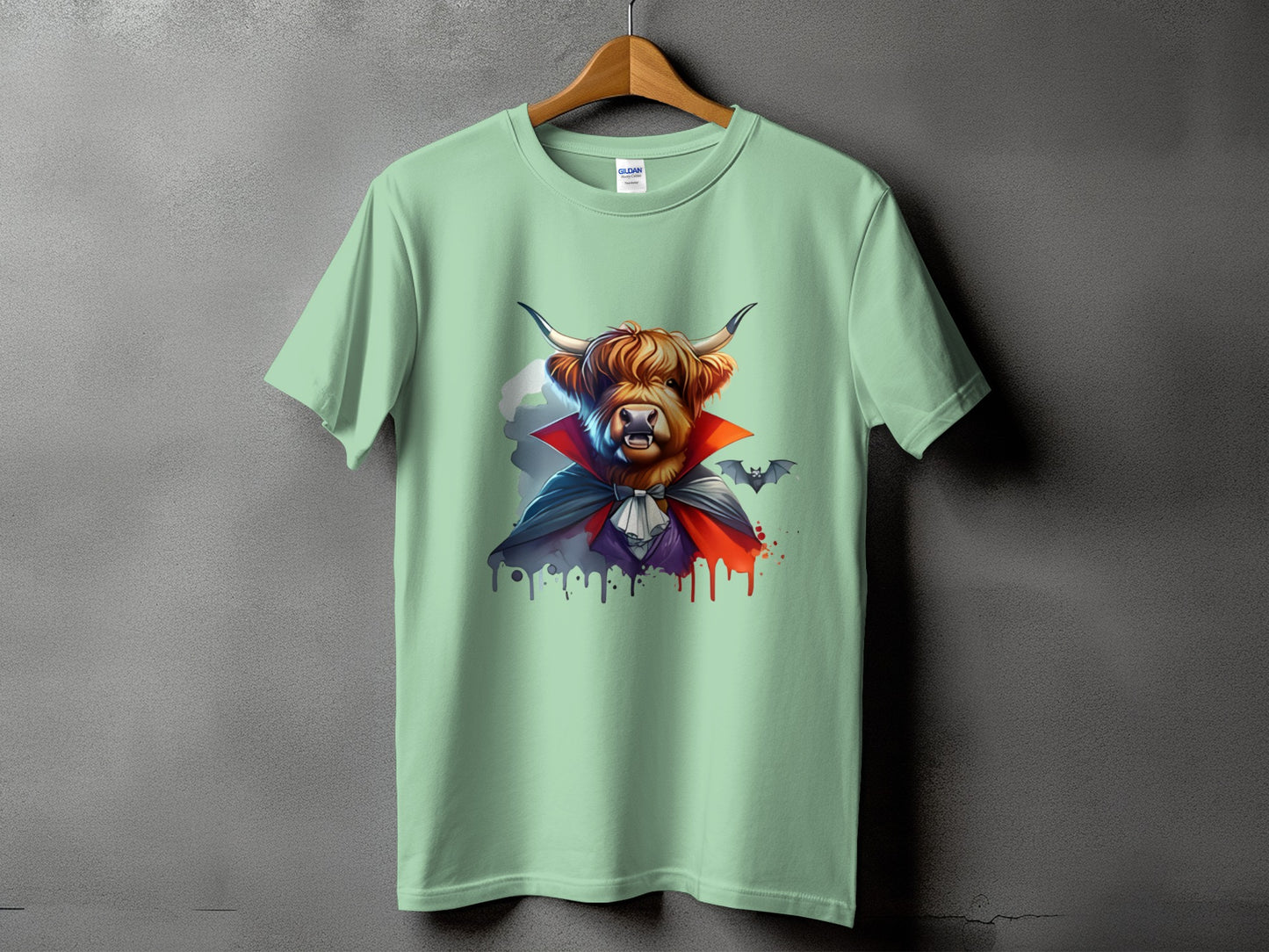 Light green t-shirt with a Highland cow dressed as a vampire and a bat.