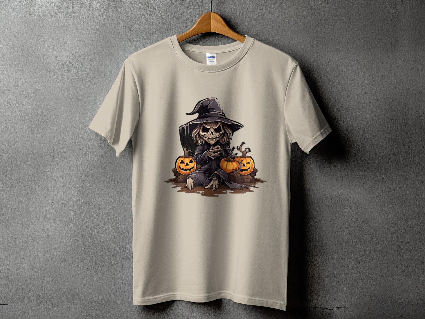 Light beige t-shirt with a Halloween-themed graphic of a skeletal figure in a witch hat and pumpkins.