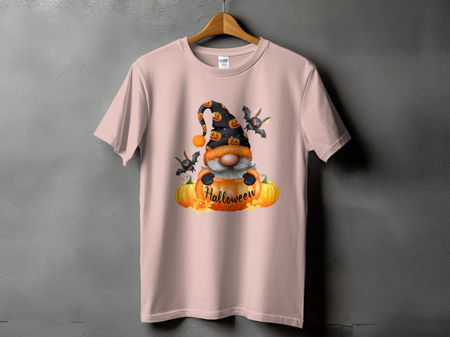 Pink t-shirt with a Halloween gnome and bats graphic, featuring pumpkins and the word "Halloween."