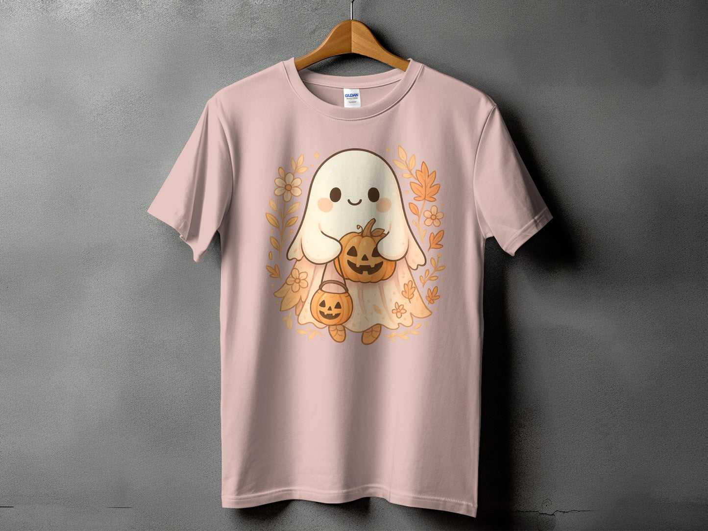 Pink t-shirt with a cute ghost holding pumpkins and surrounded by fall leaves.