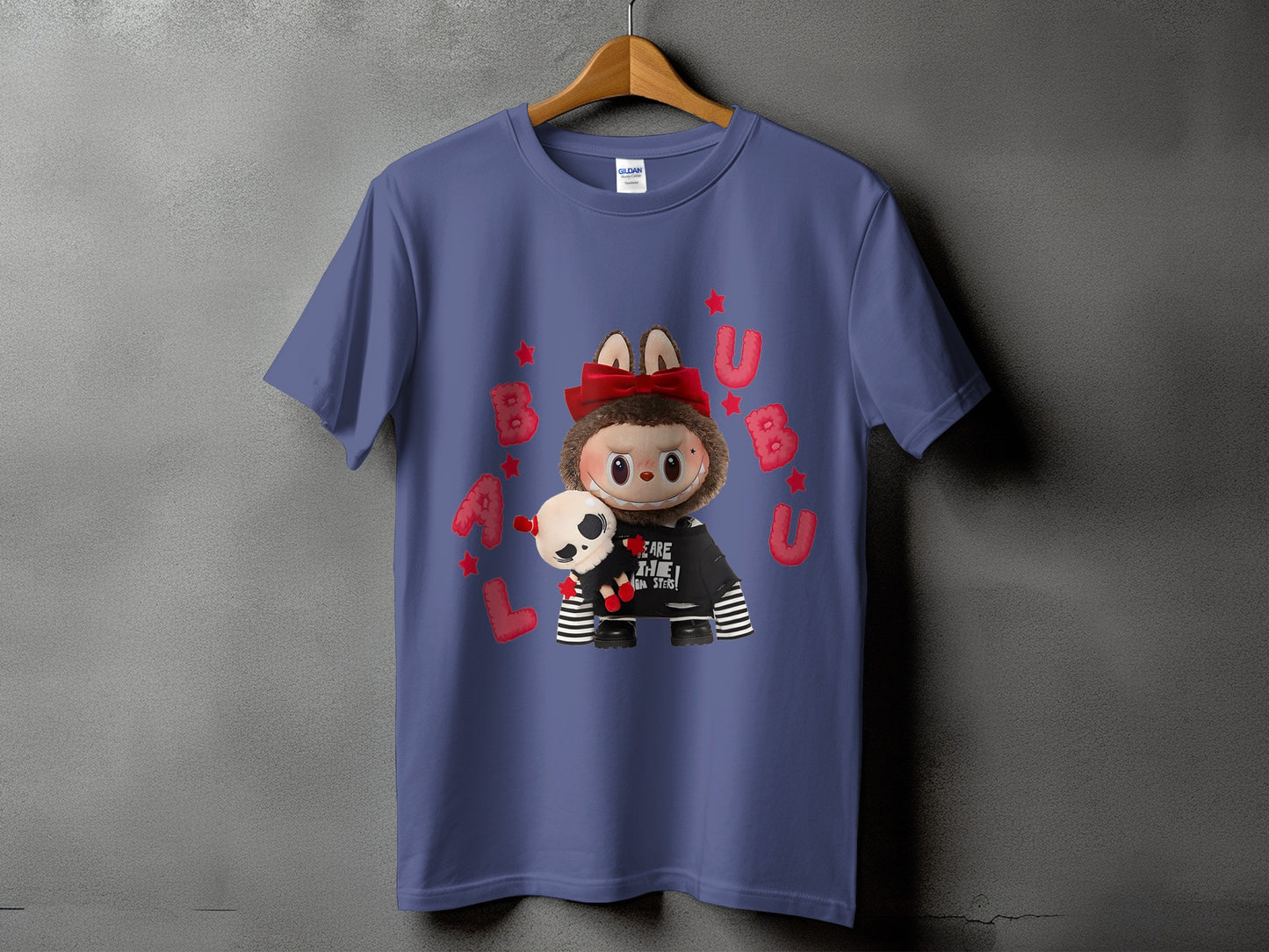 Blue t-shirt with cartoon character wearing a hoodie and holding a plush skull toy.