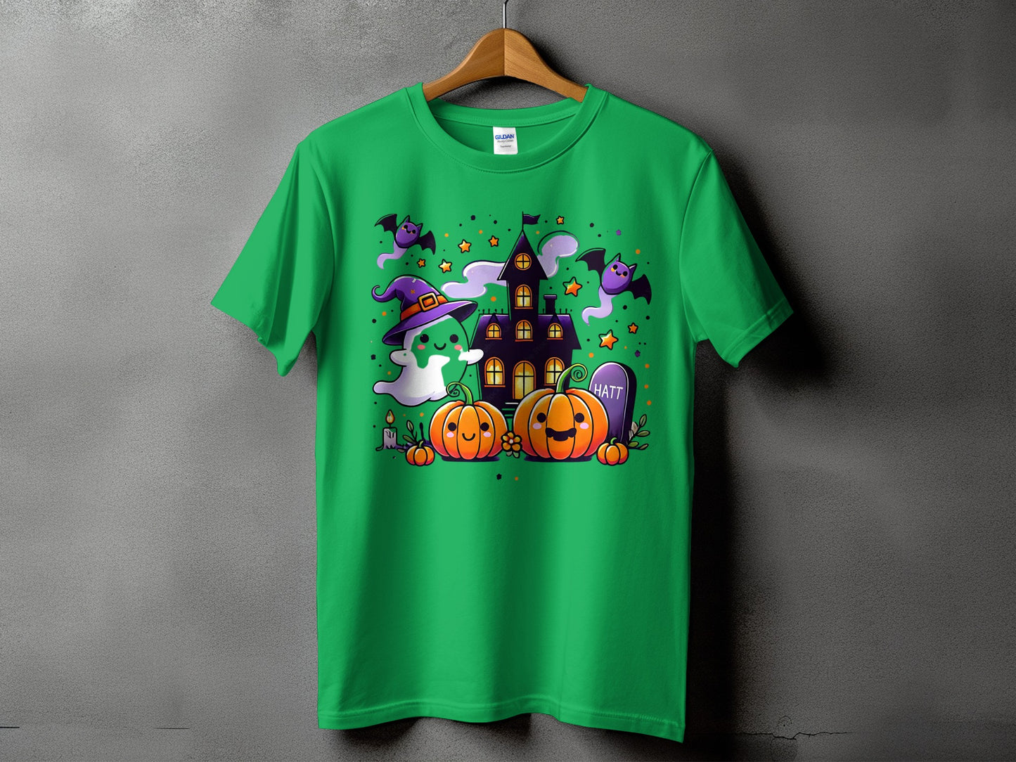 Green t-shirt with Halloween cartoon graphic featuring pumpkins, ghost, bats, and haunted house.