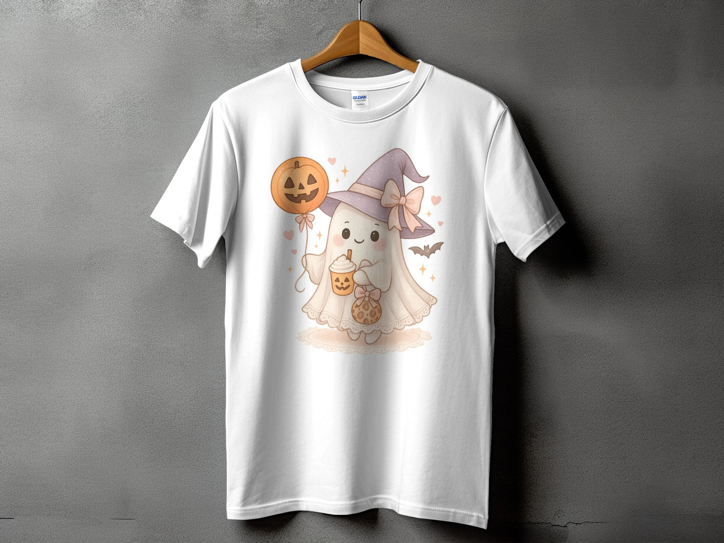 White t-shirt with a cute ghost in a witch hat holding a pumpkin balloon and drink.