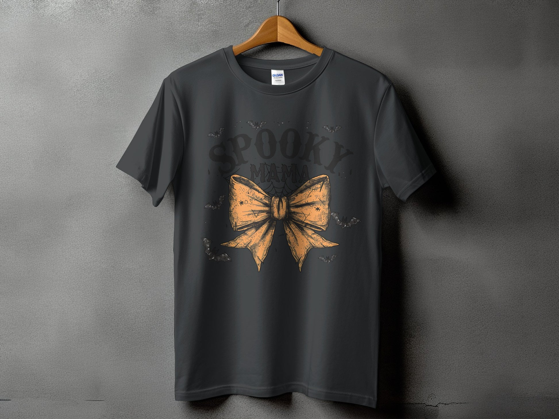 Dark gray t-shirt with "Spooky Mama" text and an orange bow graphic.