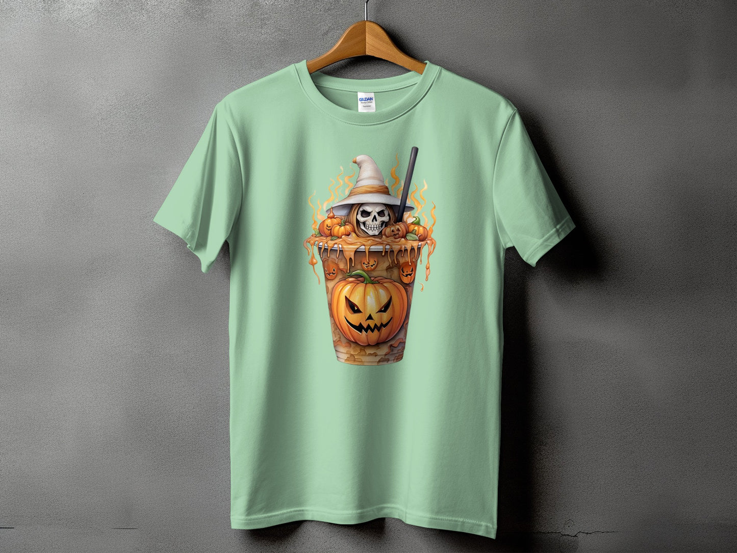 Mint green t-shirt with a Halloween-themed graphic of a skull in a witch hat with pumpkins.