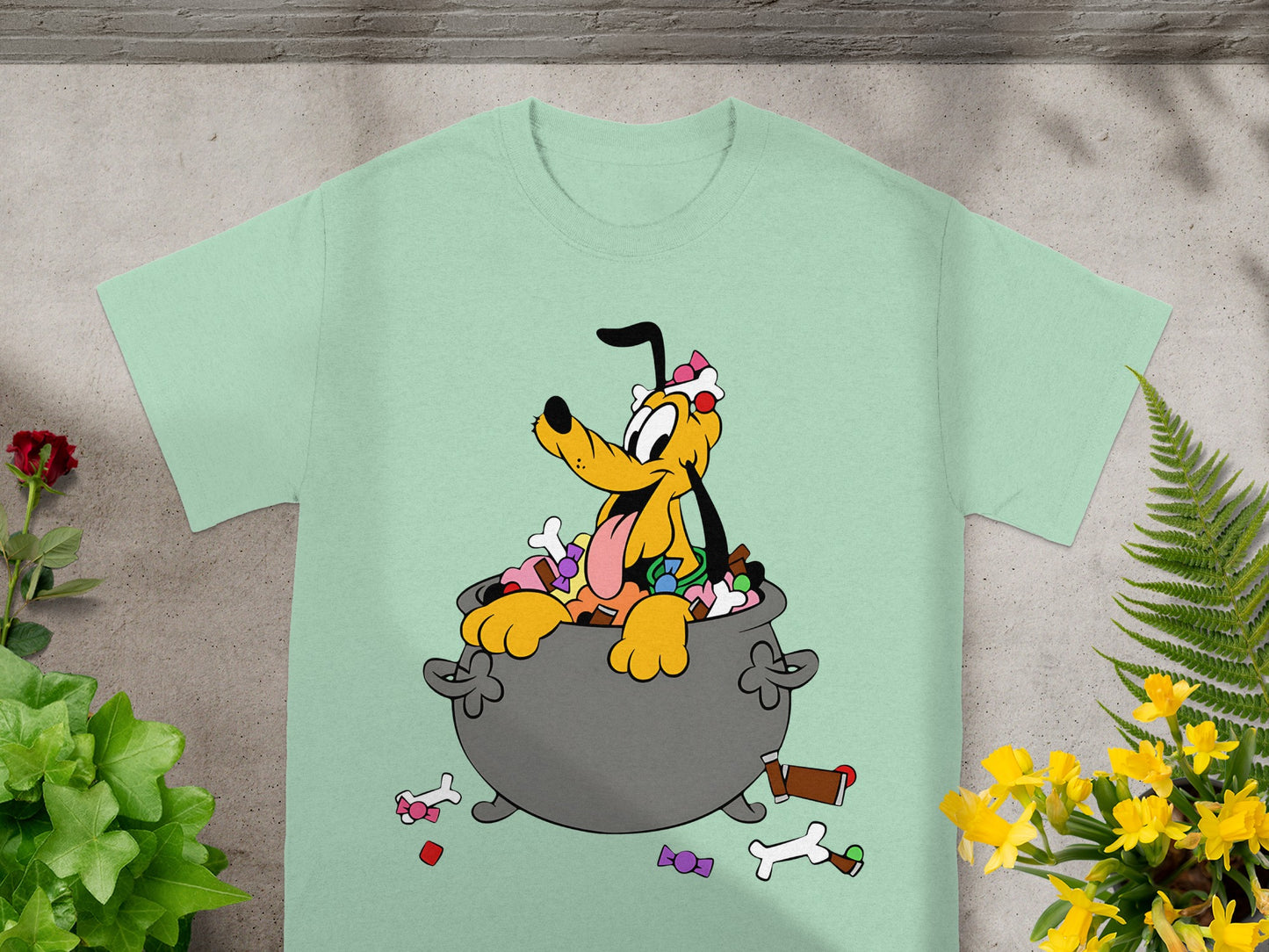 Pluto dog in cauldron overflowing with candy on a mint green t-shirt.