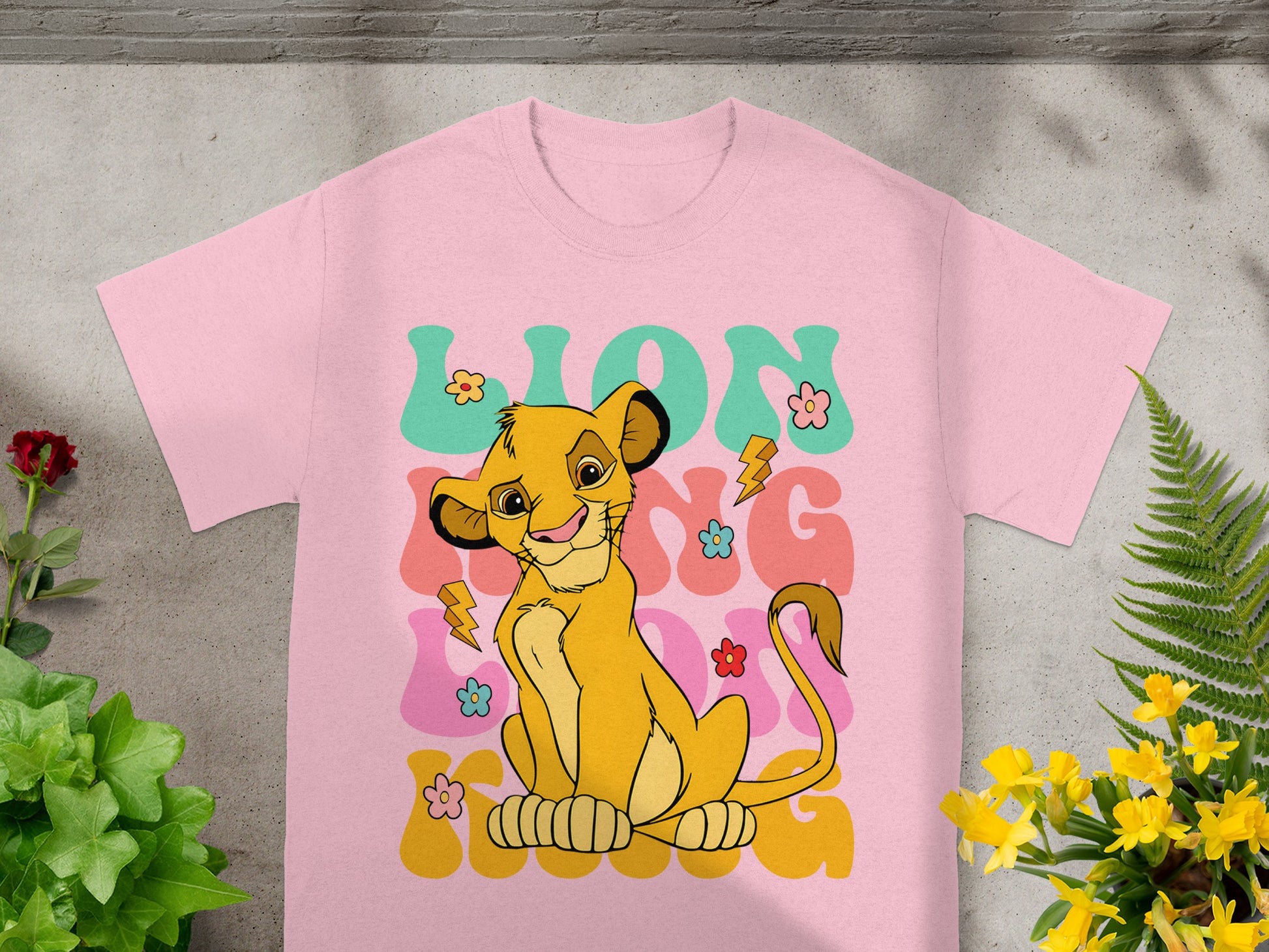 Pink t-shirt featuring Simba from The Lion King with "LION KING" text.