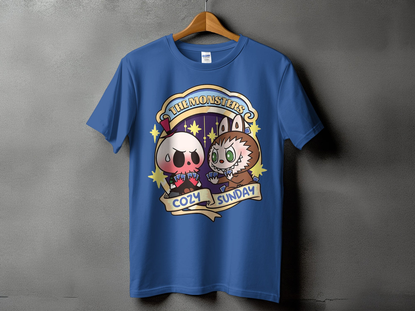 Blue t-shirt with cartoon skull and werewolf playing cards, text reads "The Monsters Cozy Sunday".